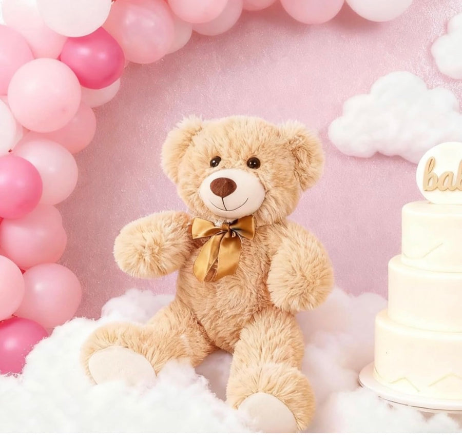 Teddy bear with a gold bow sitting on fluffy white clouds against a pink background
